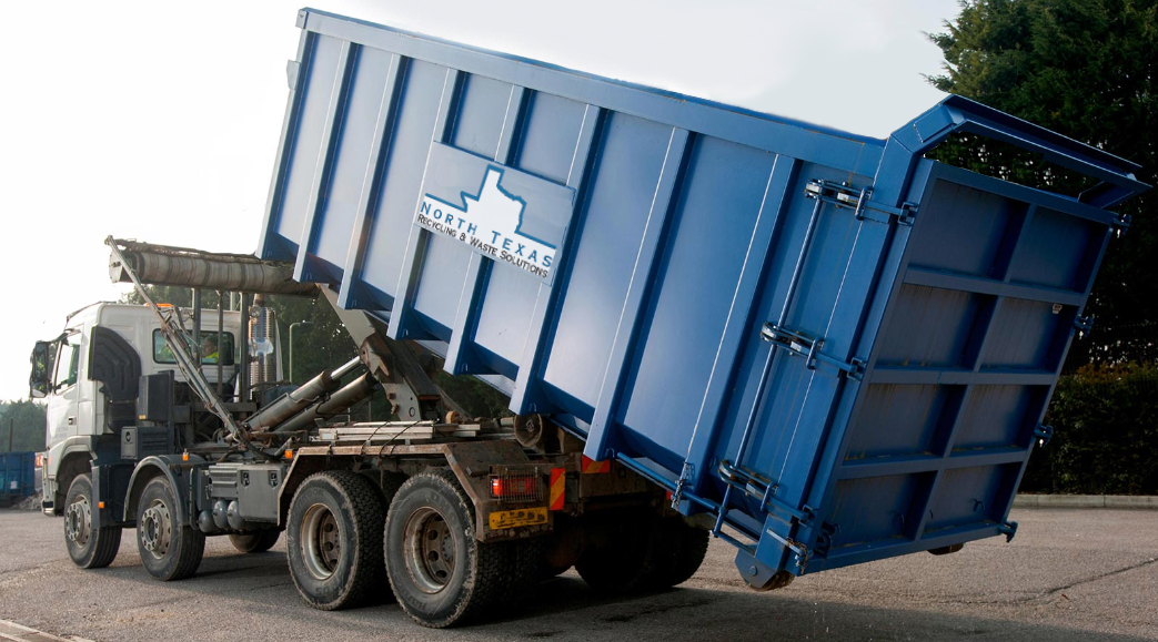Truck dropping off a roll off container at a job location